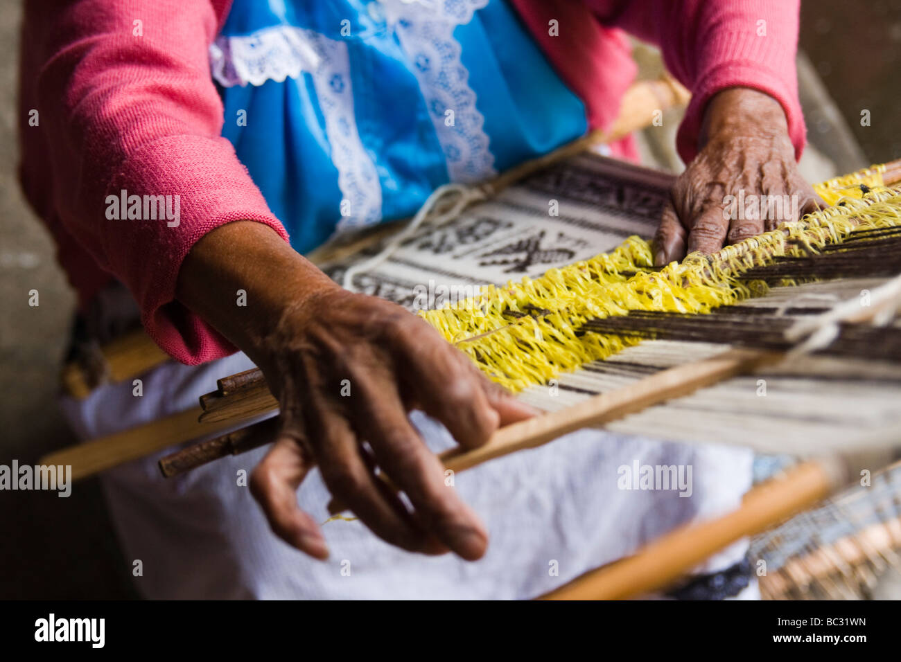 A woman weaves on a loom in Paracho, Michoacan, Mexico. Stock Photo