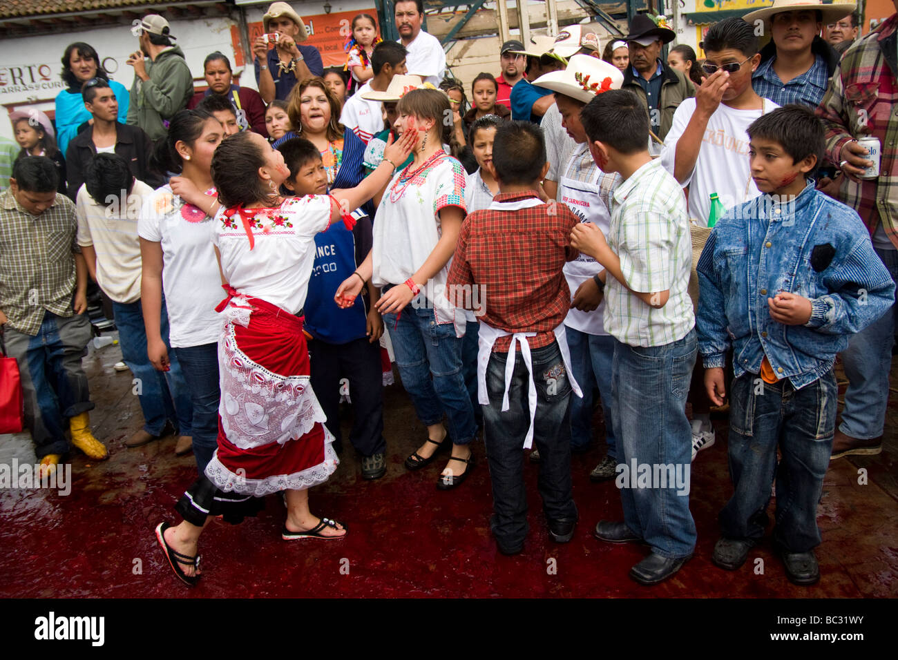 Girls play with the blood of a slaughtered bull in Paracho, Michoacan, Mexico. Stock Photo