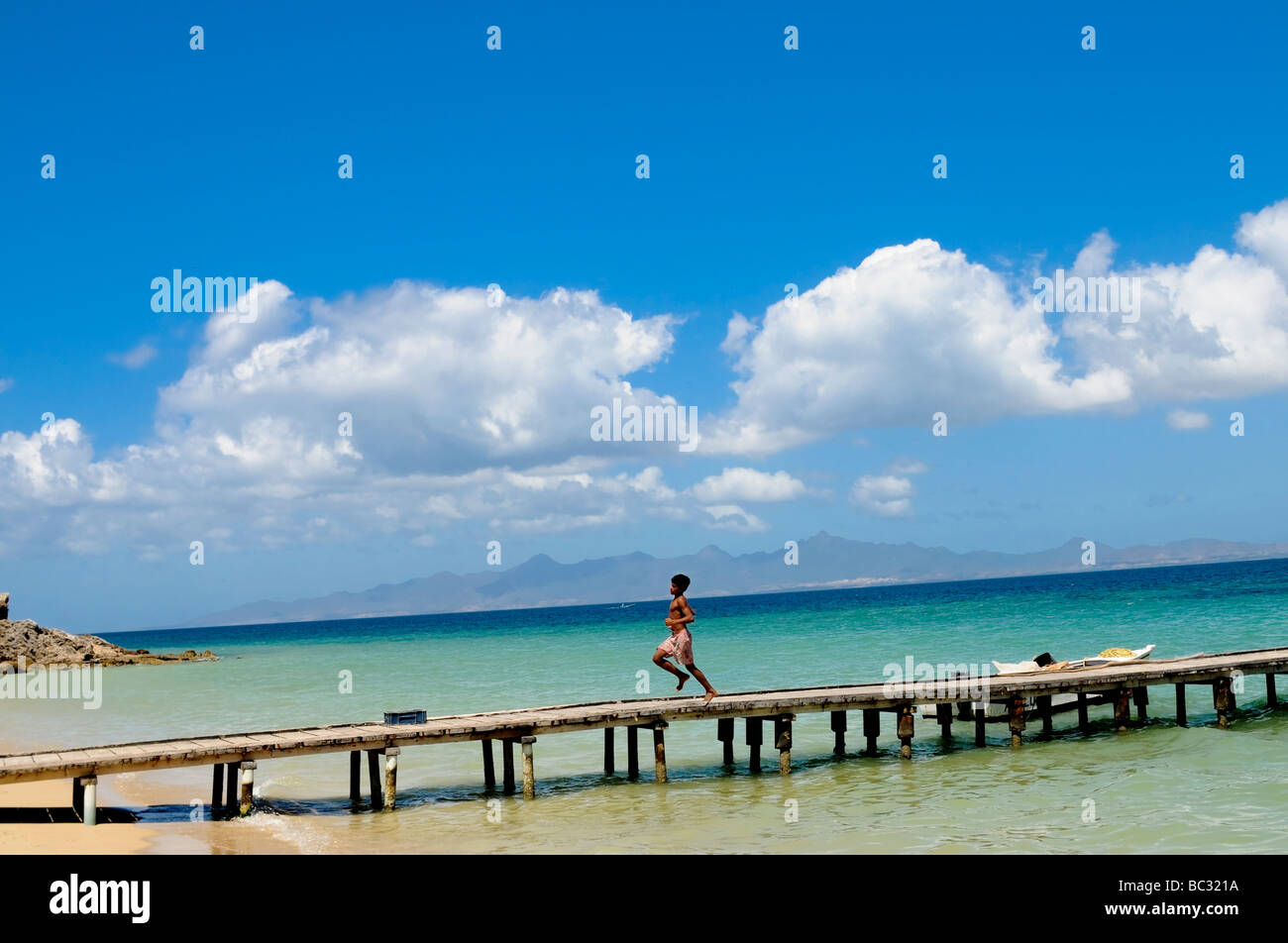 Young boy runs down dock on the Caribbean Island of Cubagua in Venezuela. Stock Photo