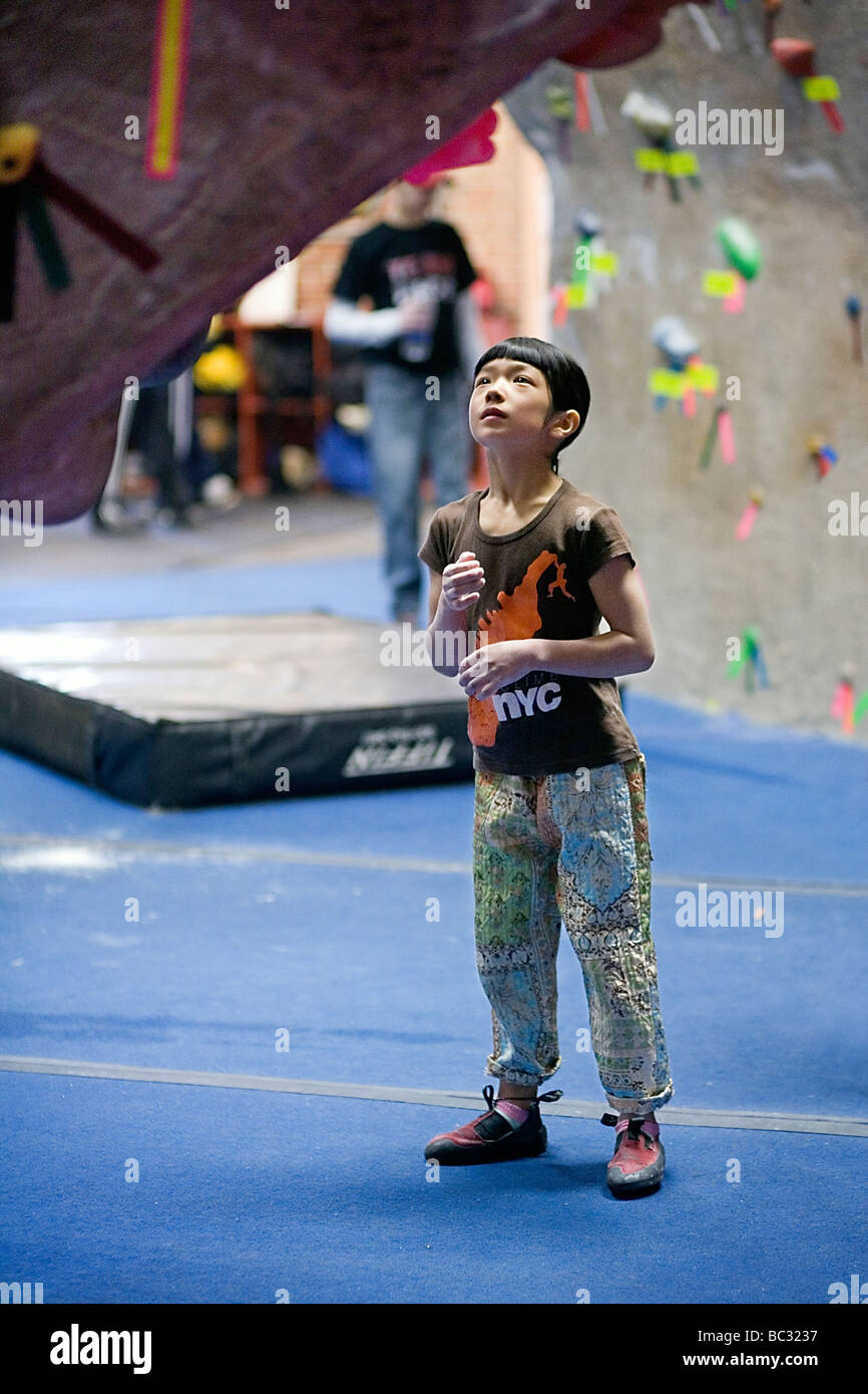 A young climber analyzing a problem in an outdoor climbing gym Stock