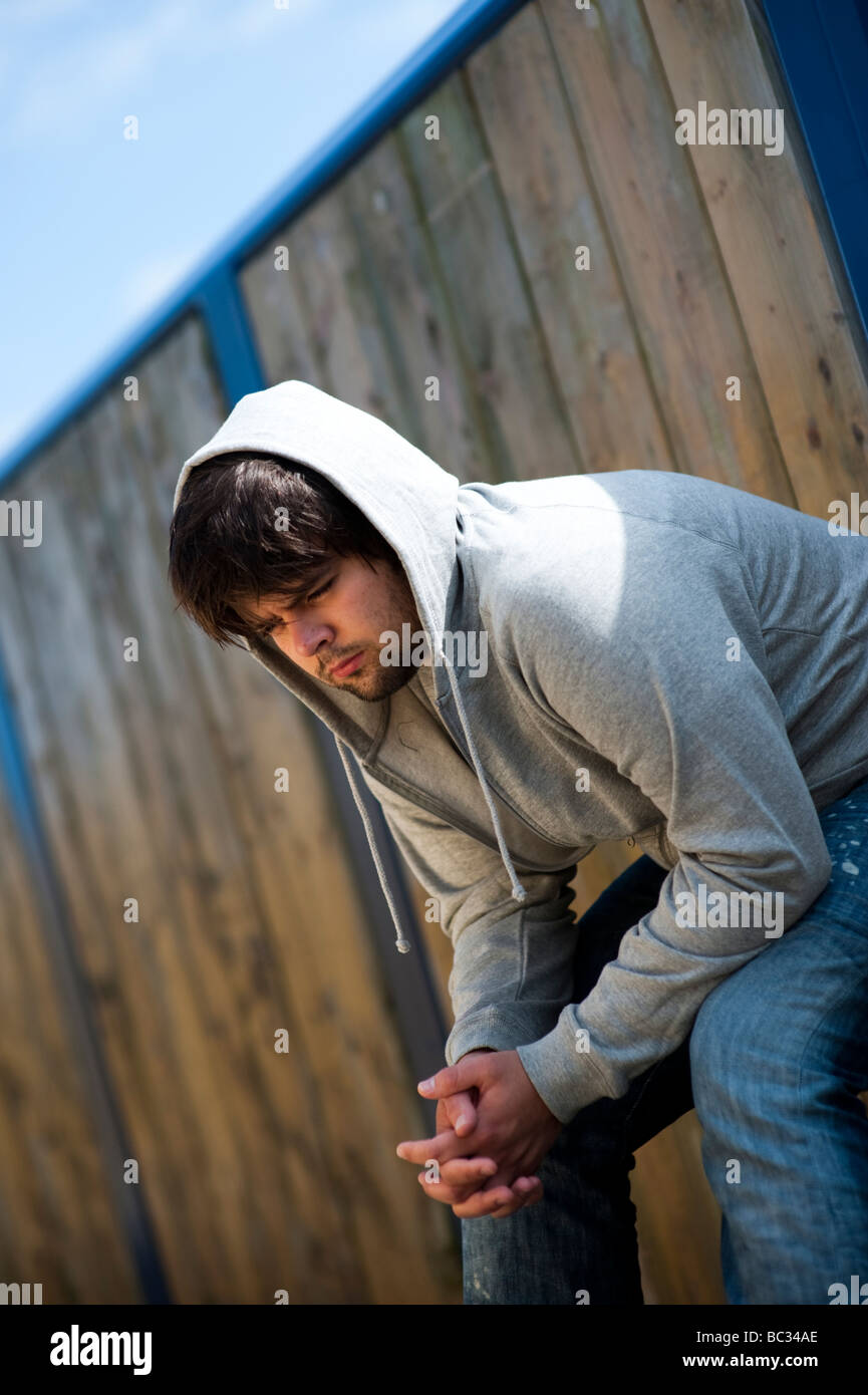 Young man wearing hoodie alone thinking thoughtful teen teenage teenager teenagers teens 20's 20s 18 19 20 21 year old Stock Photo