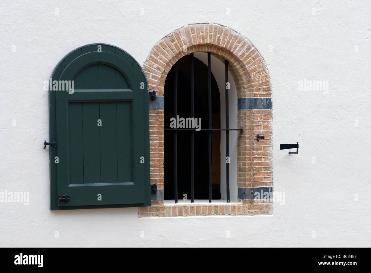 Arched windows with green wooden shutters of Cape Dutch homestead in