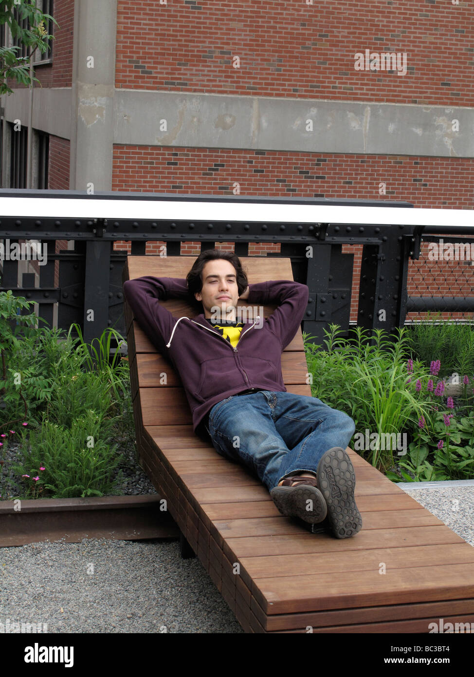 Young adult male relaxing on a lounge chair. Stock Photo