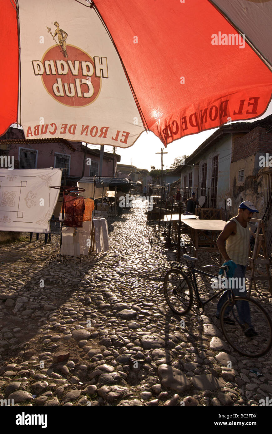 Backlit cobblestone streets of Trinidad, Cuba. Morning market. Havana club  parasol Stock Photo - Alamy