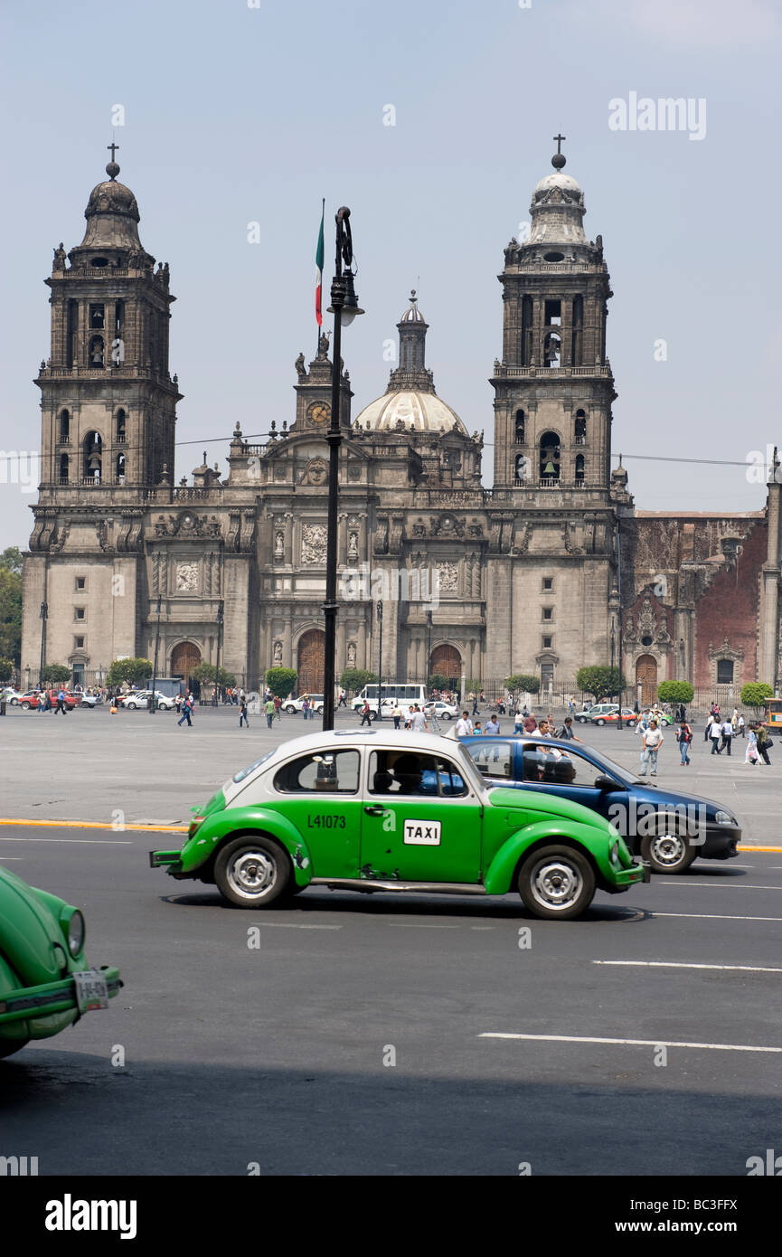 Green mexican taxis pass the Cathedral Metropolitan on El Zocalo, Mexico City. Stock Photo
