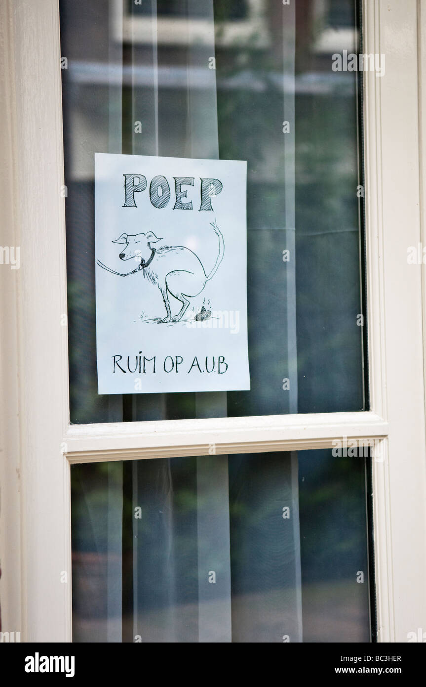 Homemade sign in the window of a house in Amsterdam asking dog-owners to clear up after their dogs. Stock Photo