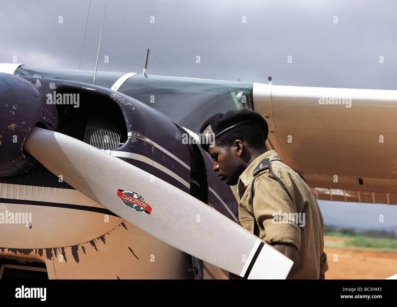 National Park Game Warden Joe Kioko inspecting Cessna single engined light aircraft prior to take off Tsavo Kenya East Africa Stock Photo