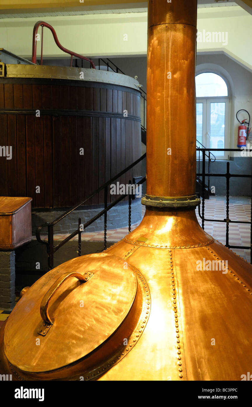 The gleaming copper, with another wooden brewing vessel background, at the Du Bocq brewery, Wallonia, Belgium. Stock Photo