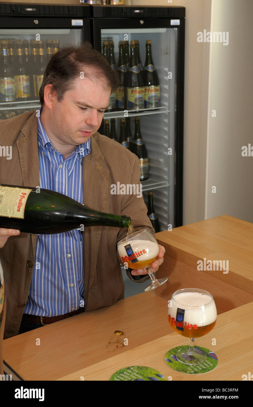 St Feuillien director of production Alexis Briol serves beer in the brewery  tasting room Stock Photo - Alamy