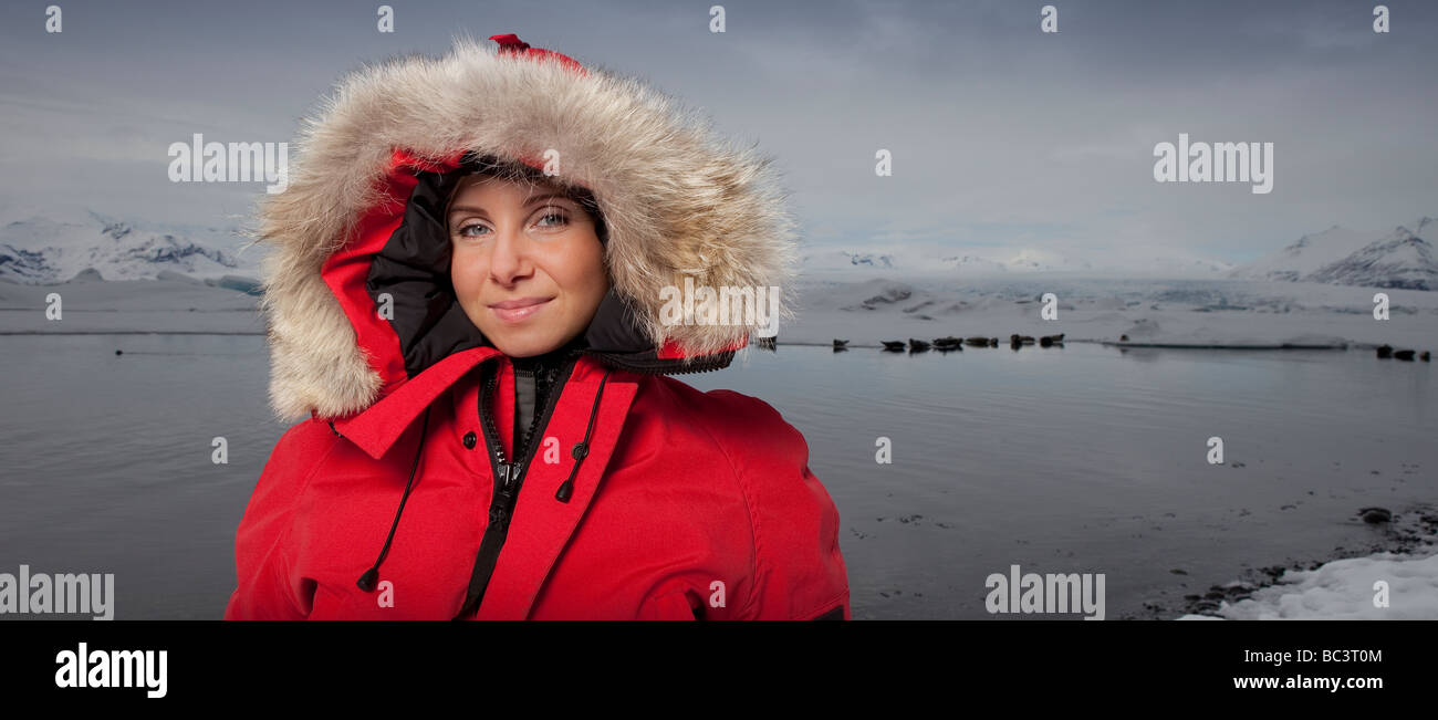 Young girl in parka seals in background,  Jokulsarlon, Breidamerkurjokull Glacier, Iceland Stock Photo