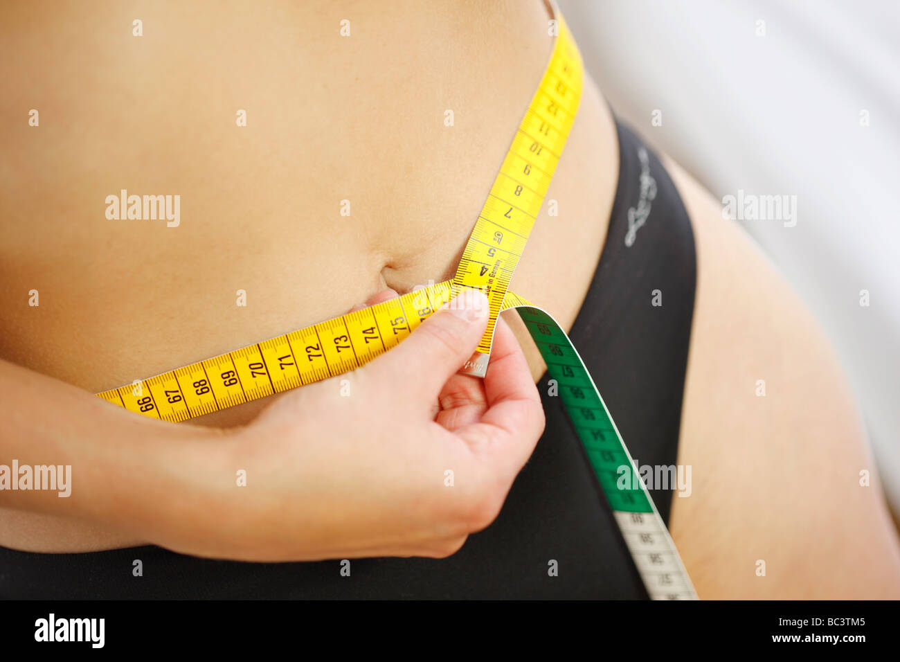 Woman is measuring her waist with a measuring tape Stock Photo Alamy