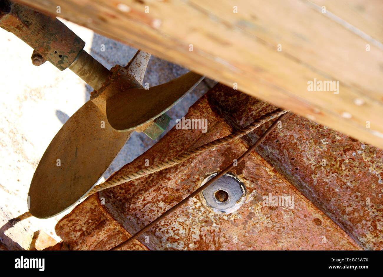 Sea aged, rusty propeller and rudder in dry dock. Stock Photo