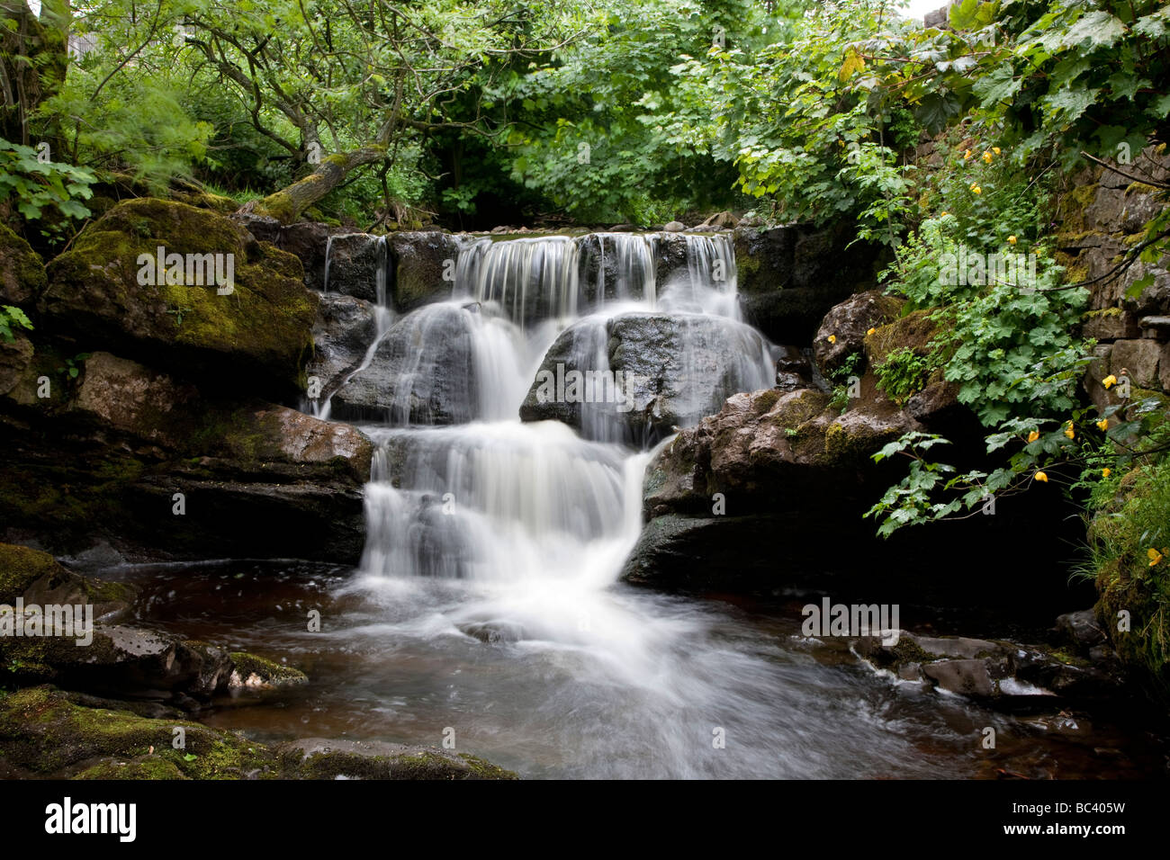Thwaite Beck waterfall at Thwaite Village Upper Swaledale Yorkshire Dales National Park Stock Photo