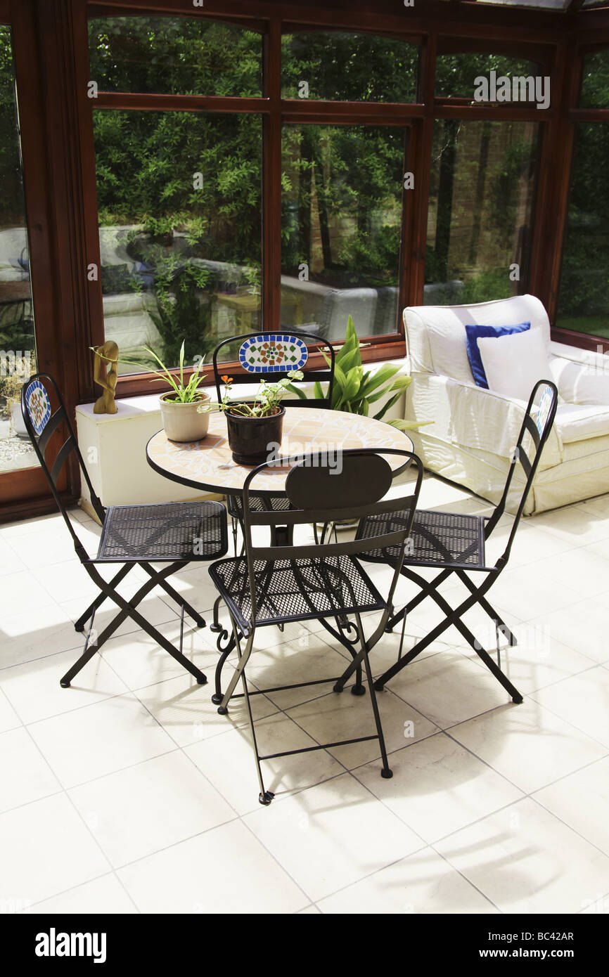 conservatory tables chairs plants room in house next to garden Stock
