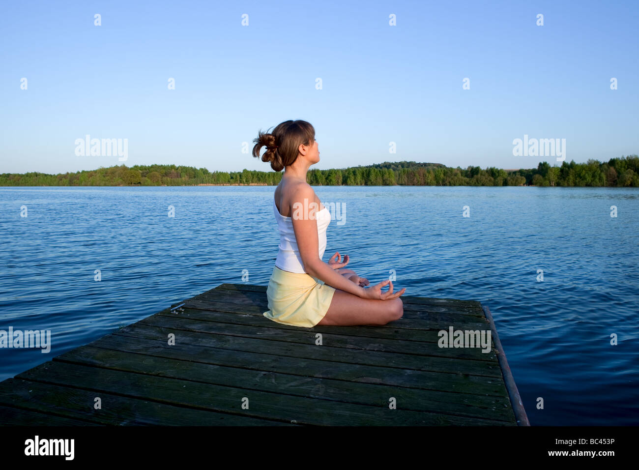 Beautiful young woman doing yoga exercise outdoors Stock Photo