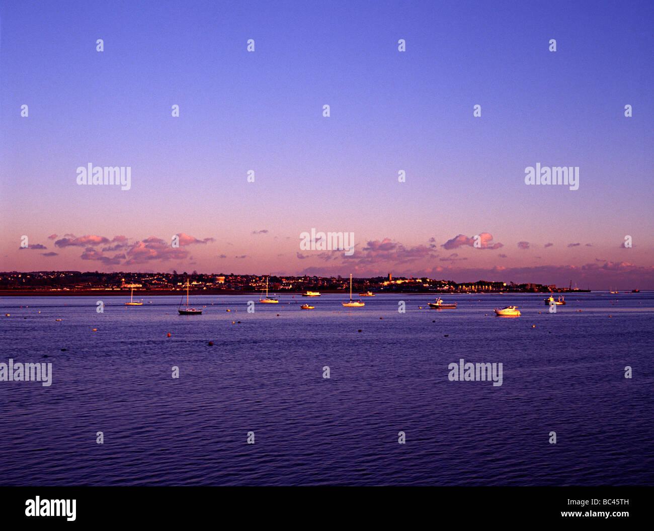 torbay estuary duing a sunset with sea boats in harbour shot from the railway Stock Photo