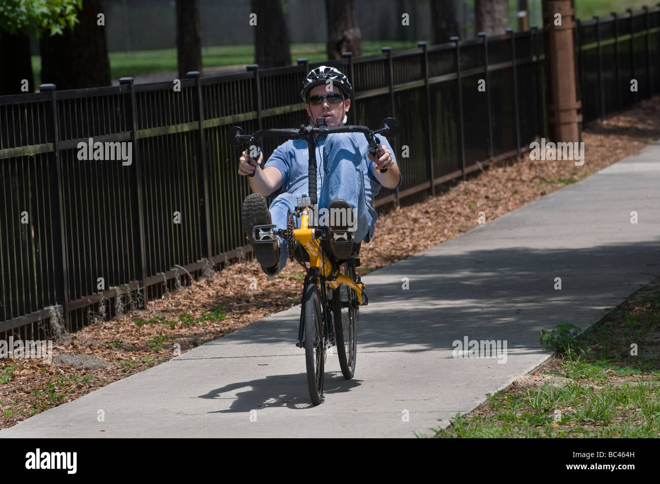 young man riding a recumbent bicycle on sidewalks of Gainesville