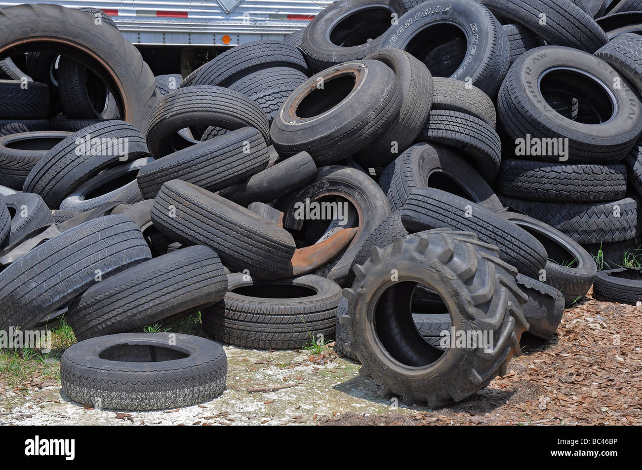 A pile of worn used tires sits in back of an auto repair shop, Florida