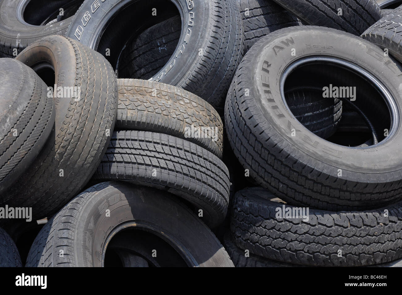 A pile of worn used tires sits in back of an auto repair shop, Florida