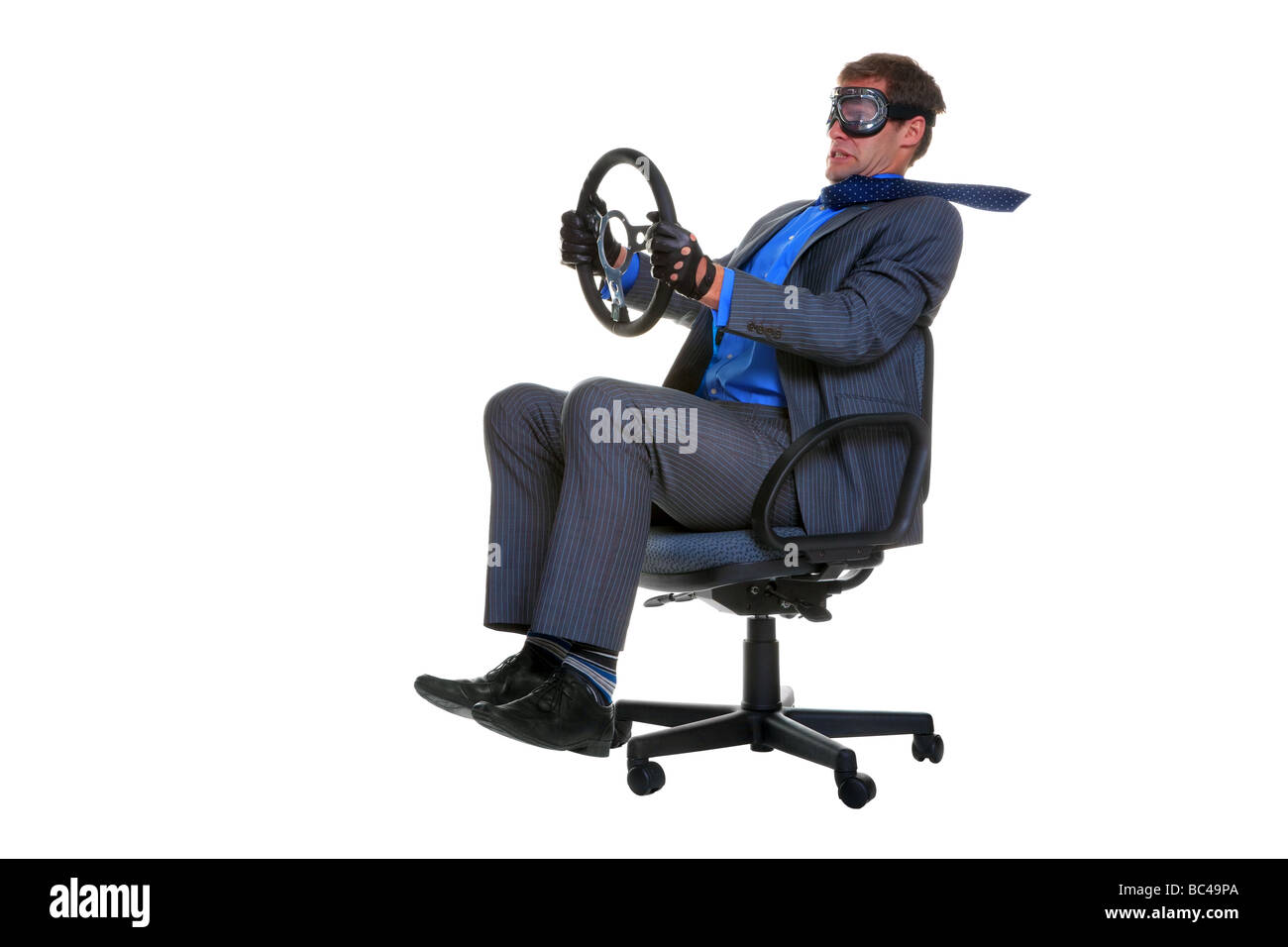 Concept image of a businessman driving along whilst sat in an office chair isolated on a white background Stock Photo