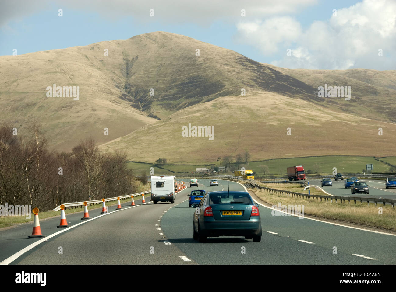 M6 Motorway northbound heading into Cumbria UK showing mountains and hills with blue sky Stock Photo