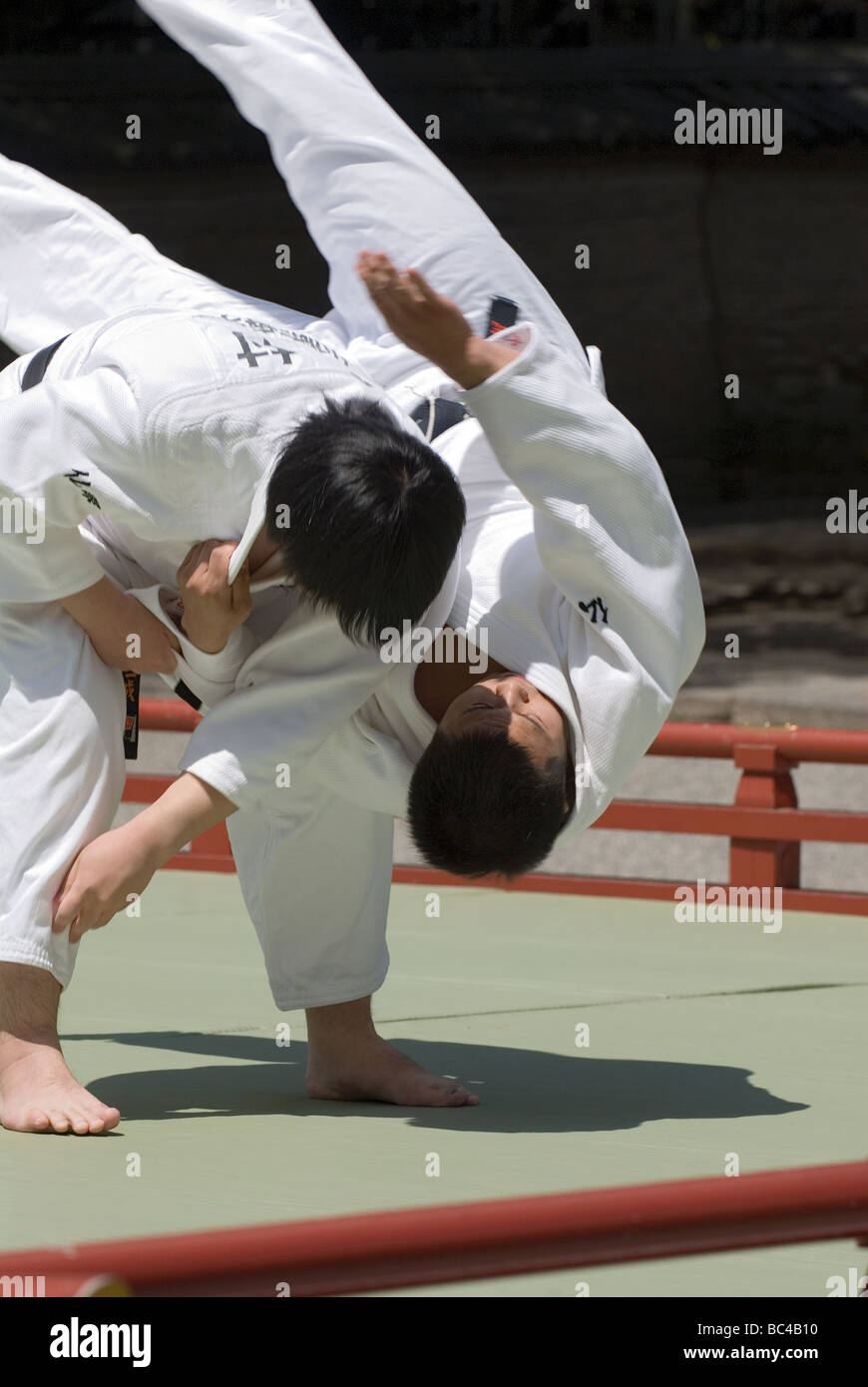 Two black belt members of a judo team perform a defensive move during a