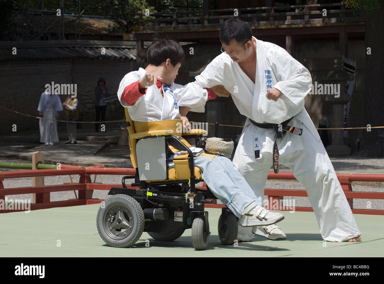 A disabled man in a wheelchair performs a defensive judo move during a martial arts