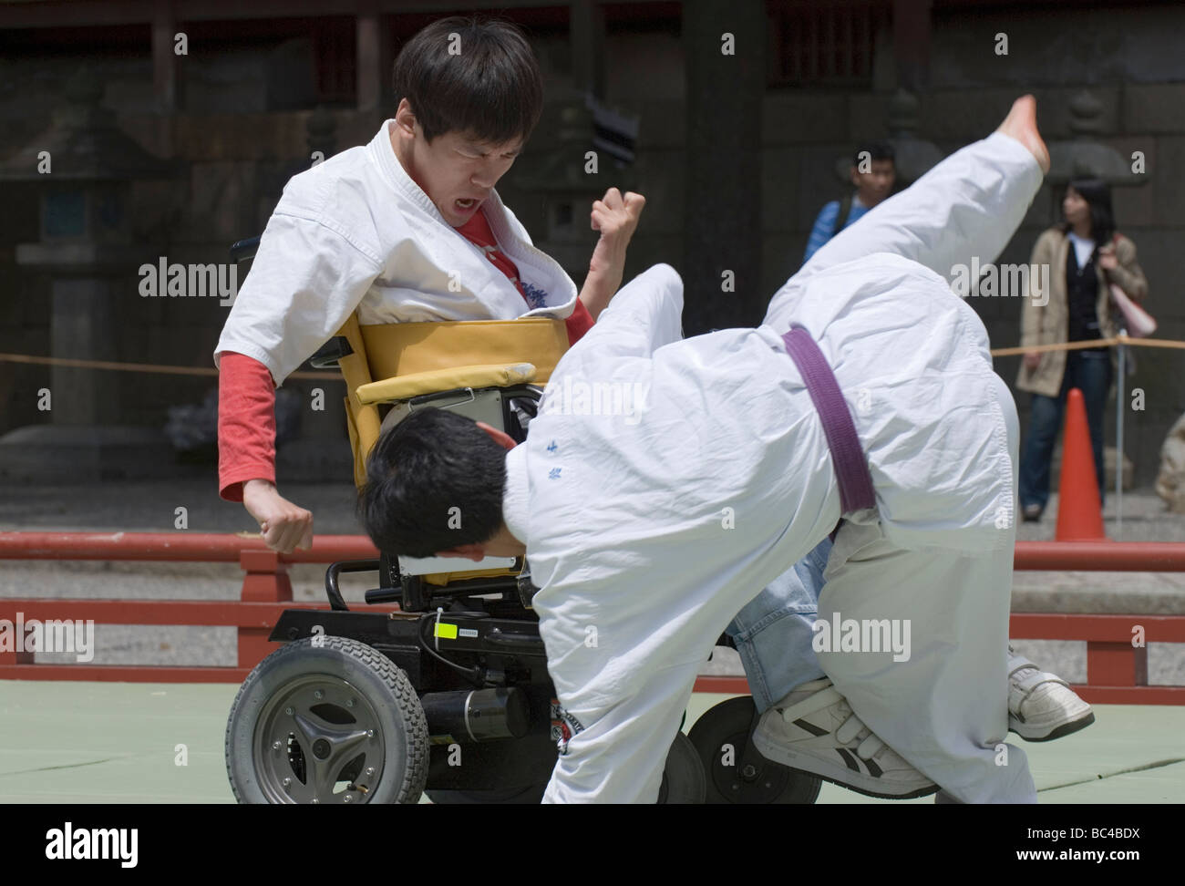 A disabled man in a wheelchair performs a defensive judo move during a martial arts