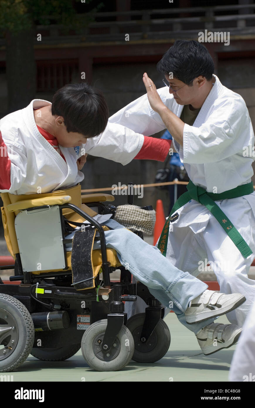 A disabled man in a wheelchair performs a defensive judo move during a