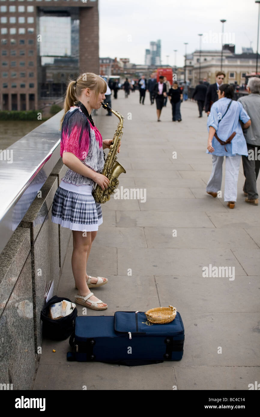 A woman plays the saxophone on London Bridge Stock Photo Alamy