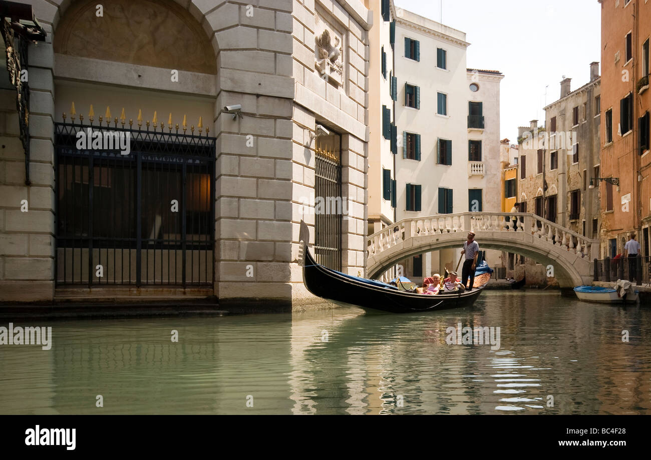 A Gondolier rows an mature couple on his gondola on the canals of