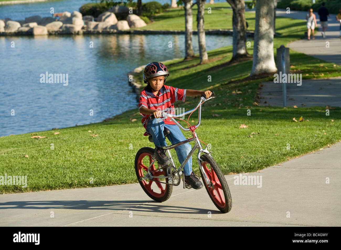 Ethnic African-American child children boy riding bicycle bicycles on path  park  6-8 years year old olds bike bikes California United States Stock Photo
