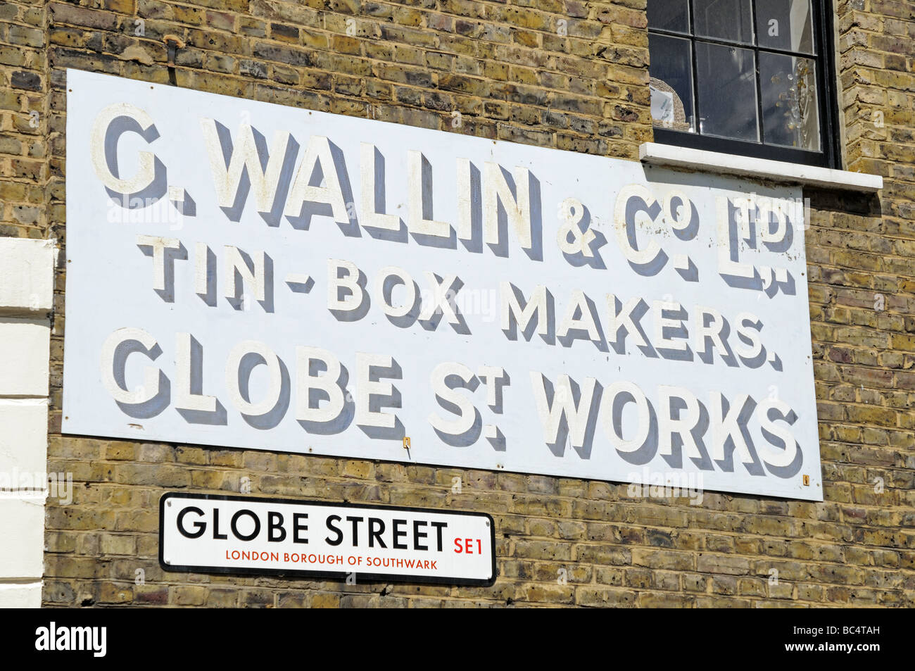 Old sign on wall for tin box makers C Wallin Globe Street Southwark London England SE1 Stock Photo