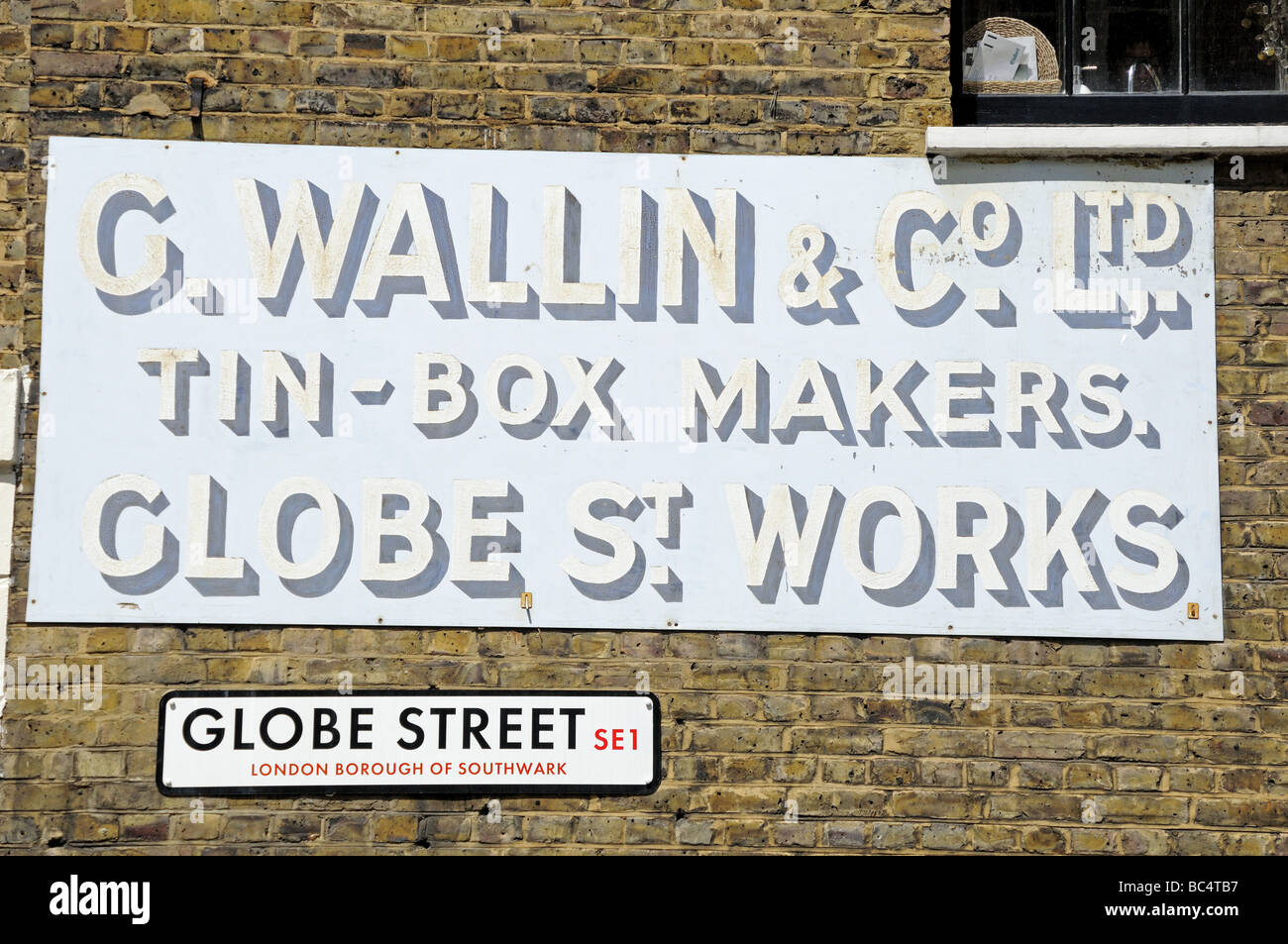 Old sign on wall for tin box makers C Wallin Globe Street Southwark London SE1 England UK Stock Photo