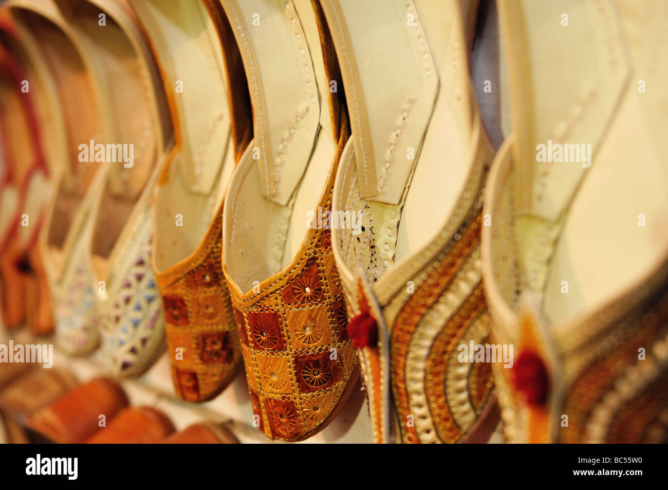 Punjabi jutti (also called mojari),  traditional handmade men's leather shoes, line the walls of a local cobblers store. Stock Photo