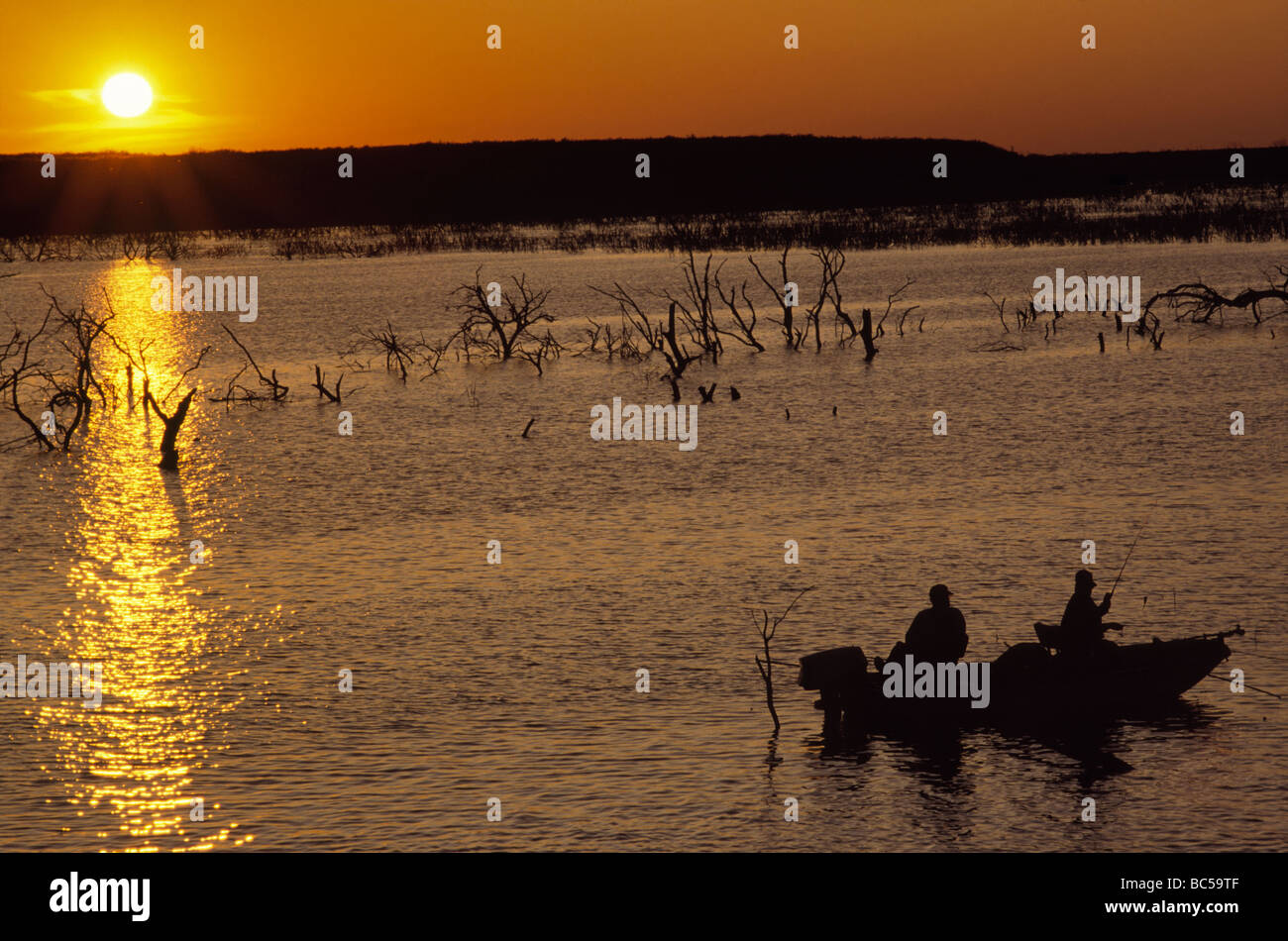Anglers on boat fishing at sunset at Choke Canyon Reservoir in Choke