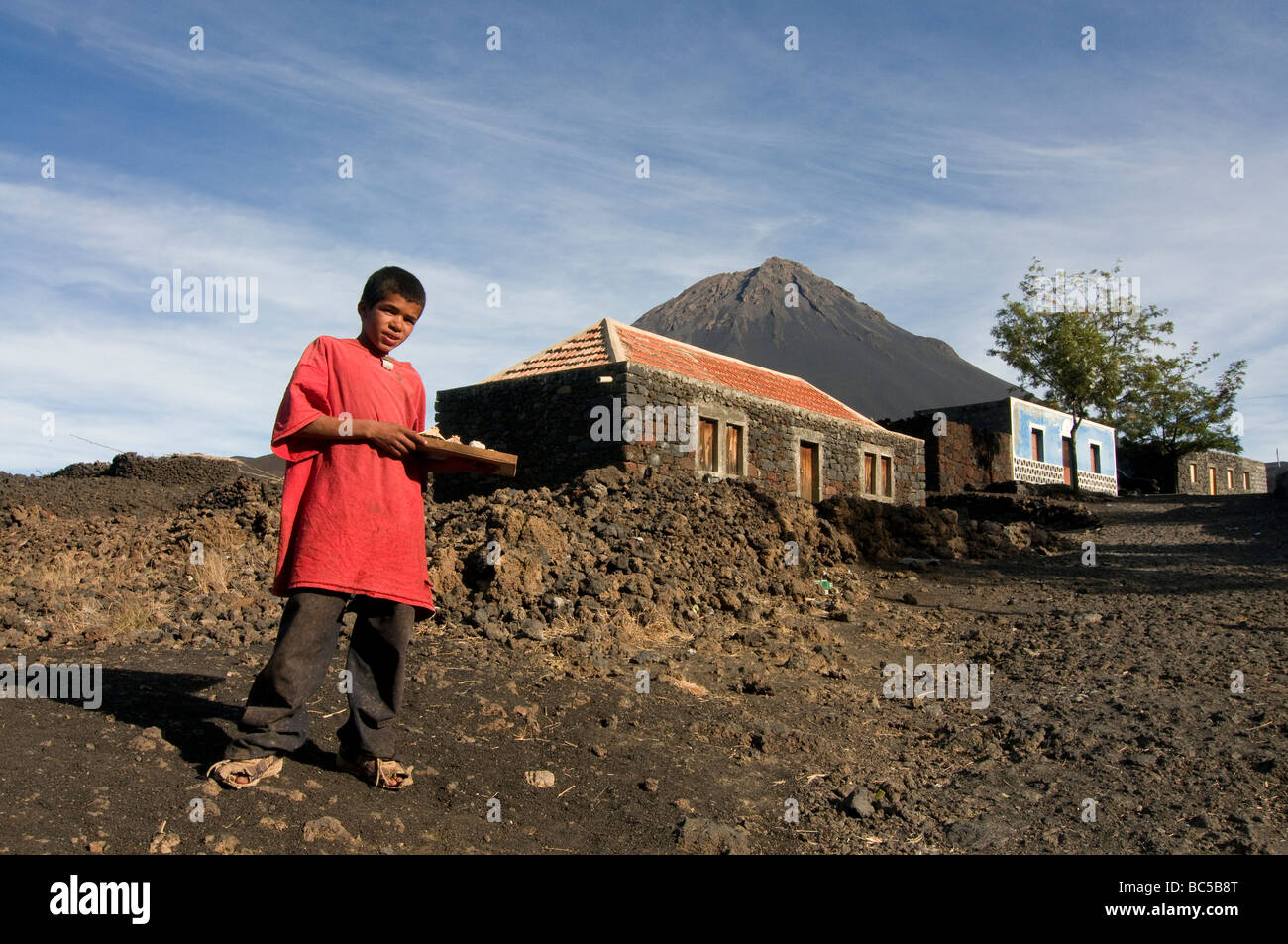 Native boy selling something in front of his house vulcano in background Fogo Cabo Verde Africa Stock Photo