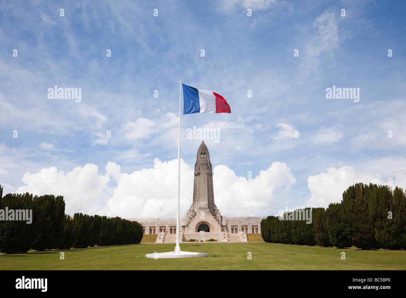 Douaumont Verdun France French tricolour and Ossuary Ossuaire de Douaumont at the National war cemetery for battle of Verdun Stock Photo