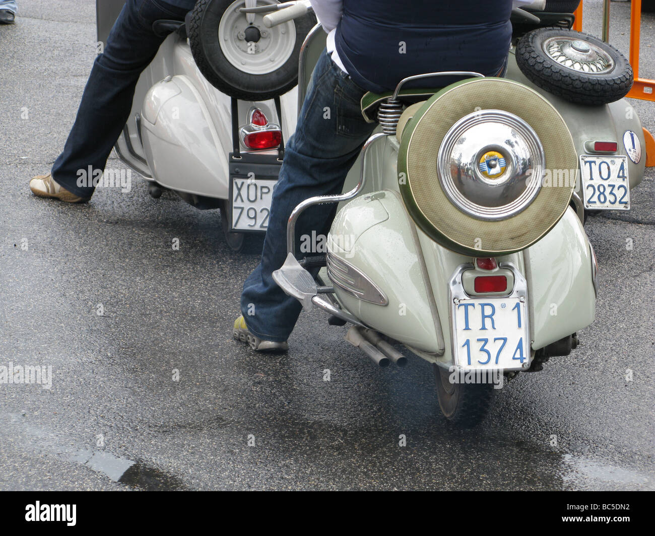 people riding old style lambretta vespa type scooters mopeds in rain in  rome italy Stock Photo - Alamy