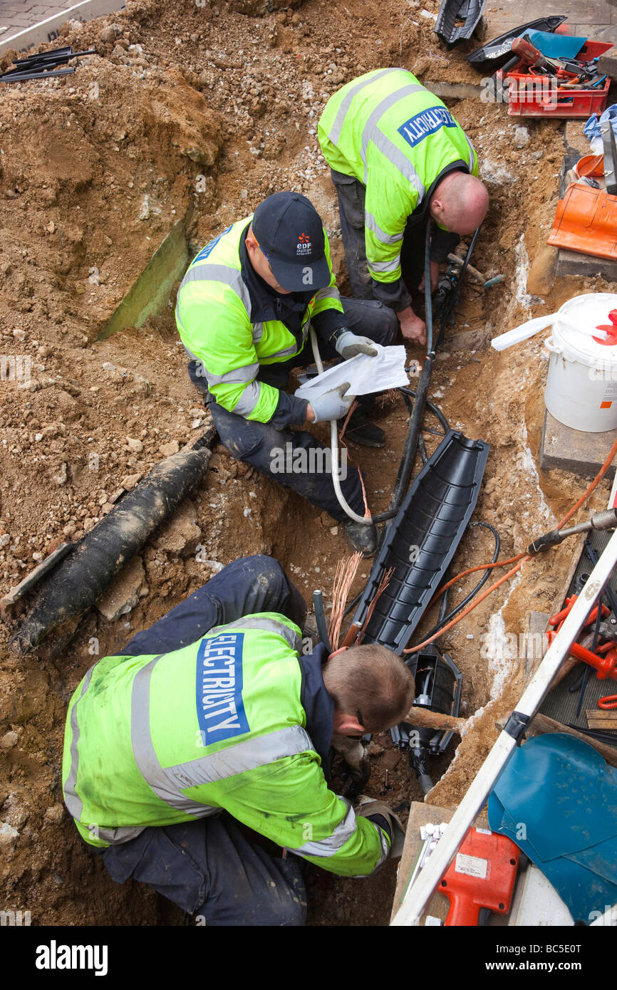 EDF workers repairing an electrical cable in the ground Stock Photo
