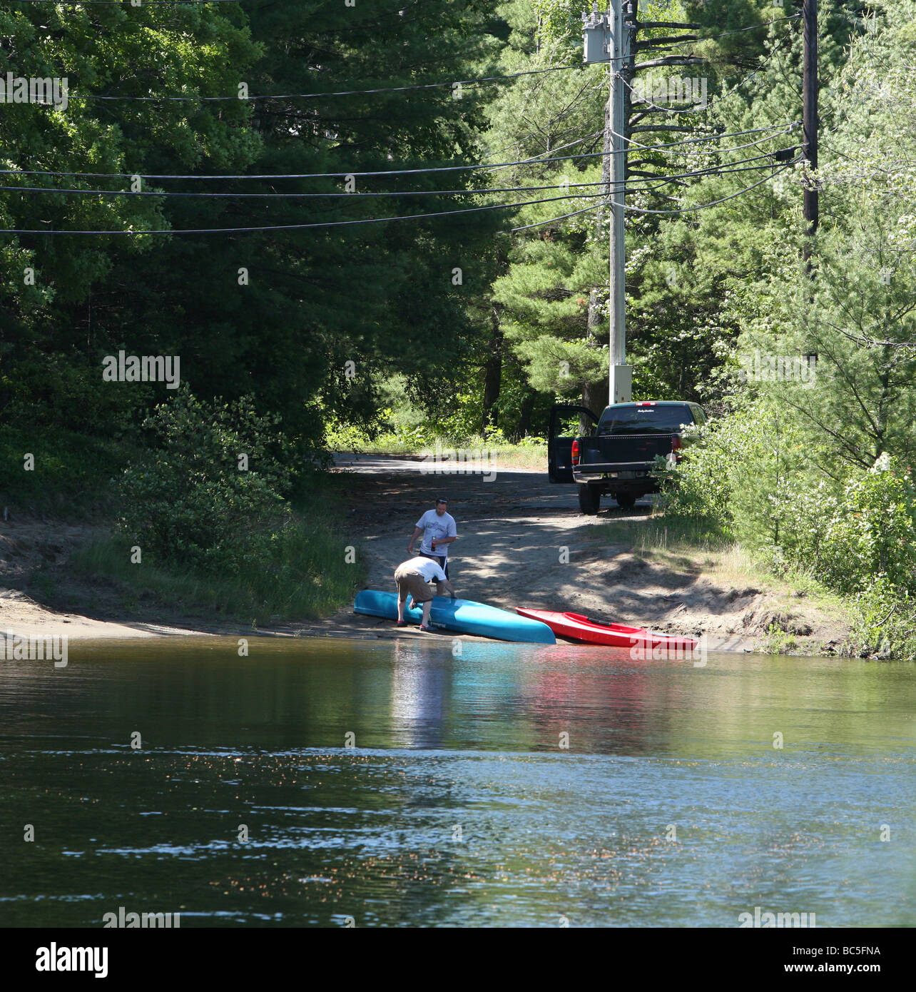 A kayak and a canoe being taken out of the Schroon River in the