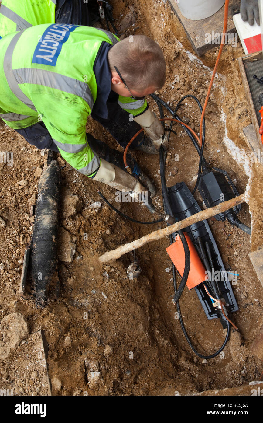 EDF workers repairing an electrical cable in the ground Stock Photo