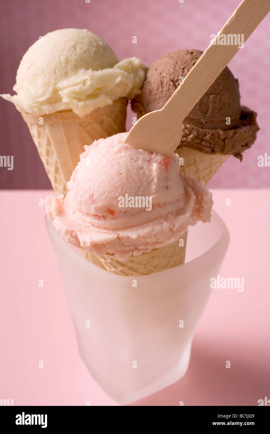 Strawberry, chocolate & vanilla ice cream in cones, ice cream spoon - Stock Photo