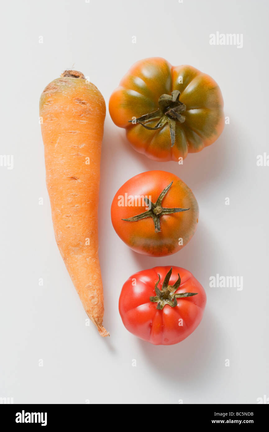 One carrot and three tomatoes - Stock Photo