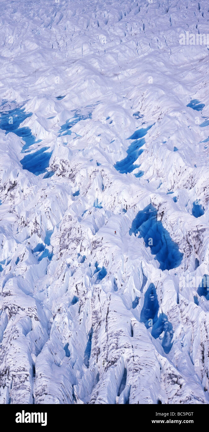 Aerial shot of a glacier with huge blue lakes and a tiny human figure which gives the scene scale Stock Photo