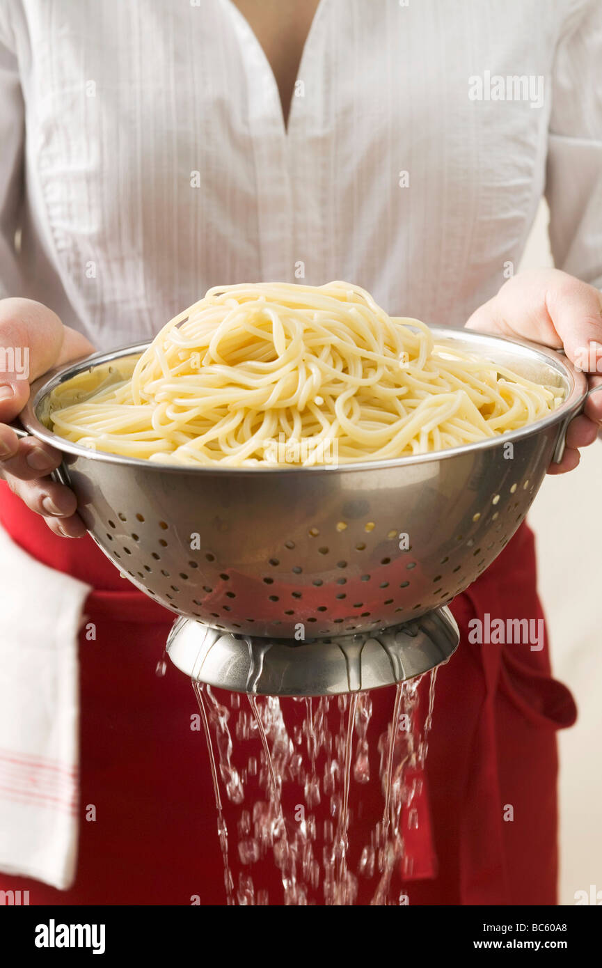 Draining cooked spaghetti Stock Photo Alamy