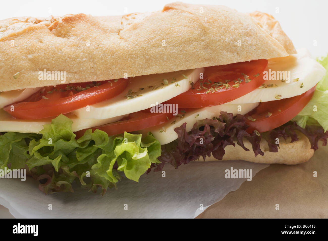 Baguette roll filled with mozzarella and tomato - Stock Photo