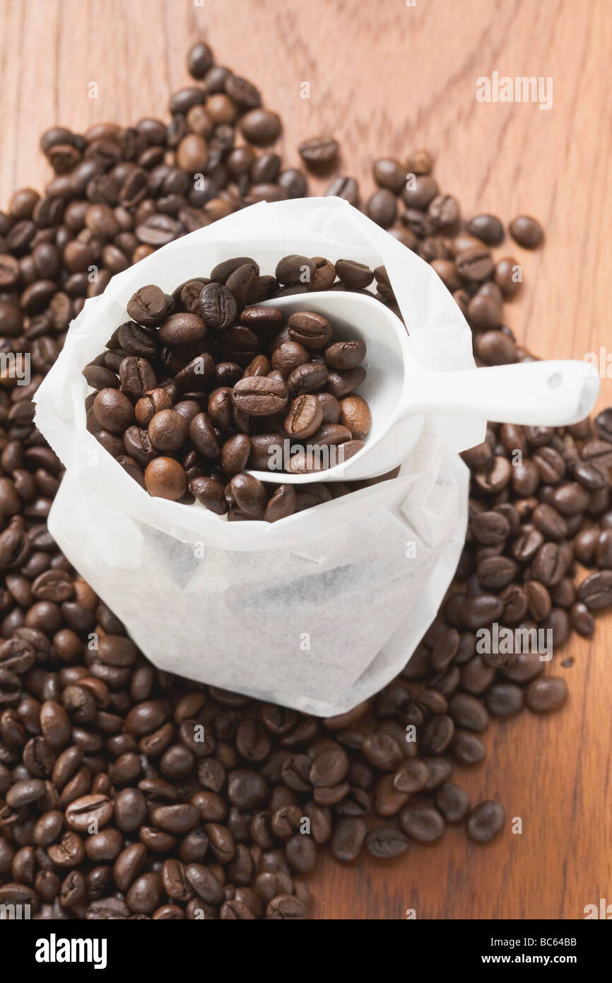 Coffee beans, in and around sack with scoop Stock Photo Alamy