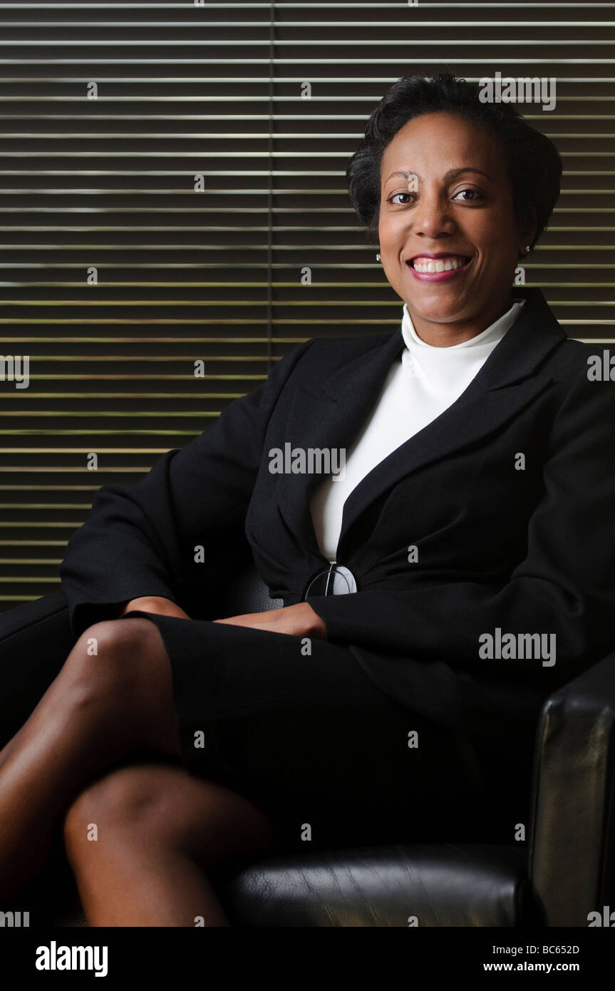 African American business woman in a black suit sitting in front of ...