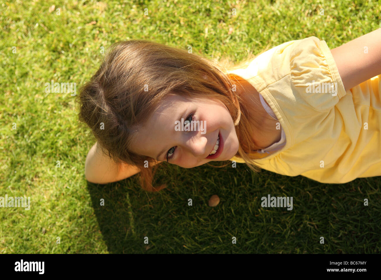 young girl lying on lawn in summertime Stock Photo - Alamy